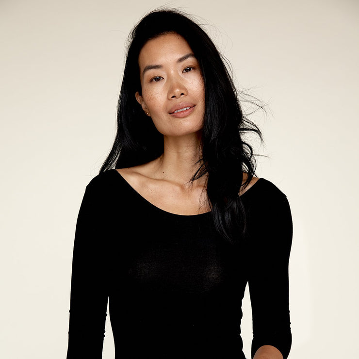 Woman wearing The Three Quarter undershirt from Numi in black, with the crew neck side