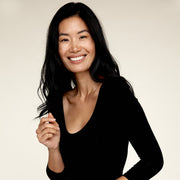 Woman smiling while wearing The Three Quarter undershirt from Numi in black