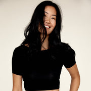 Woman wearing The Crop undershirt from Numi in black, with the crewneck side