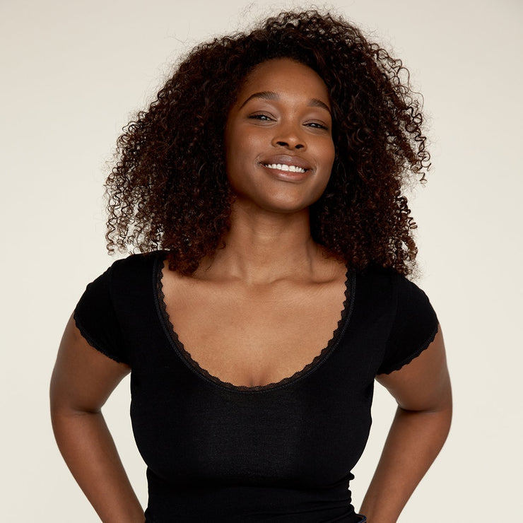 Woman smiling while wearing The Lace undershirt from Numi in black